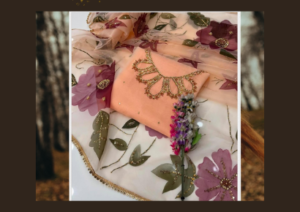 "Peach organza dress with handcrafted neckline and 3D floral embroidered dupatta, ideal for formal and festive occasions."